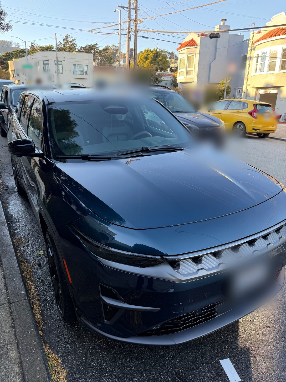 Clean hood and front end of a dark blue Jeep Wagoneer S after detailing