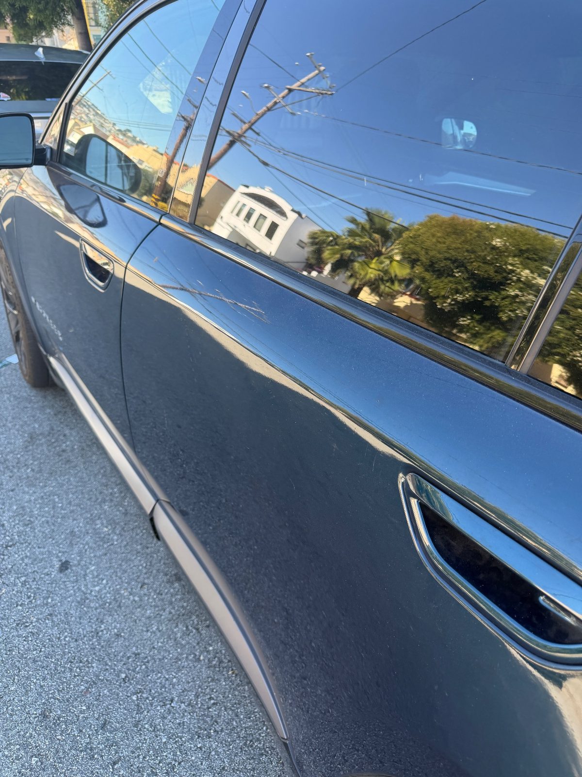 Light scratch marks on the rear door of a Jeep Wagoneer S before detailing