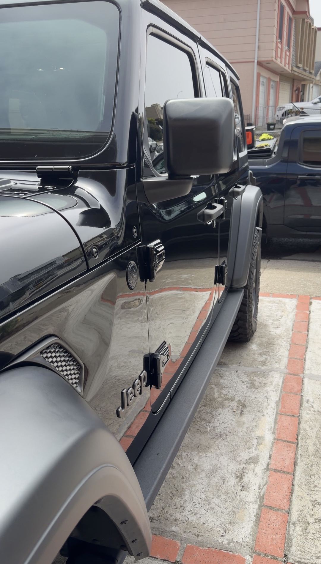 Clean black Jeep Wrangler front door, mirror and Jeep fender badge after an exterior detail