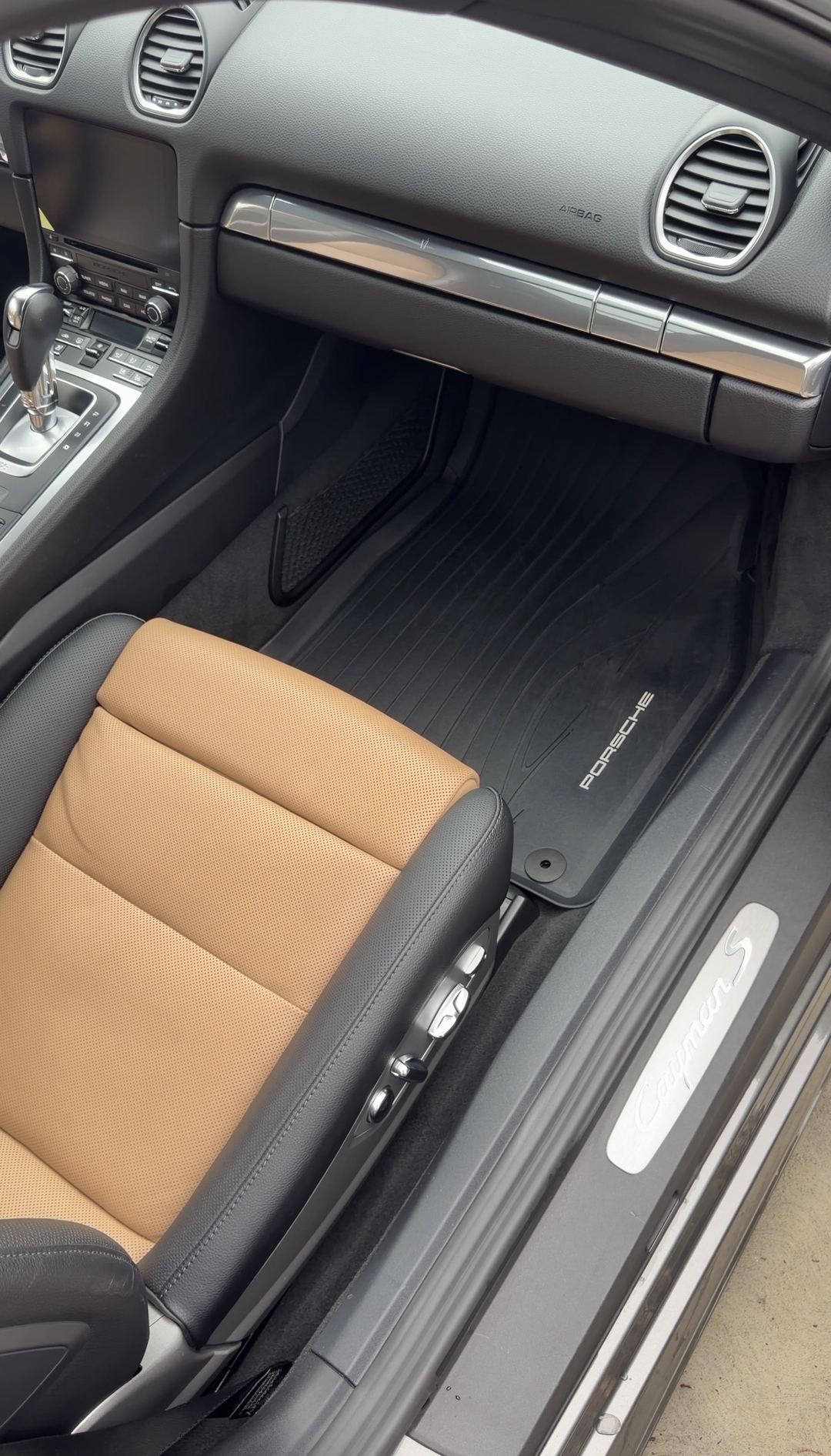 Clean passenger footwell and floor mat of a Porsche 718 Cayman S after an interior detail.