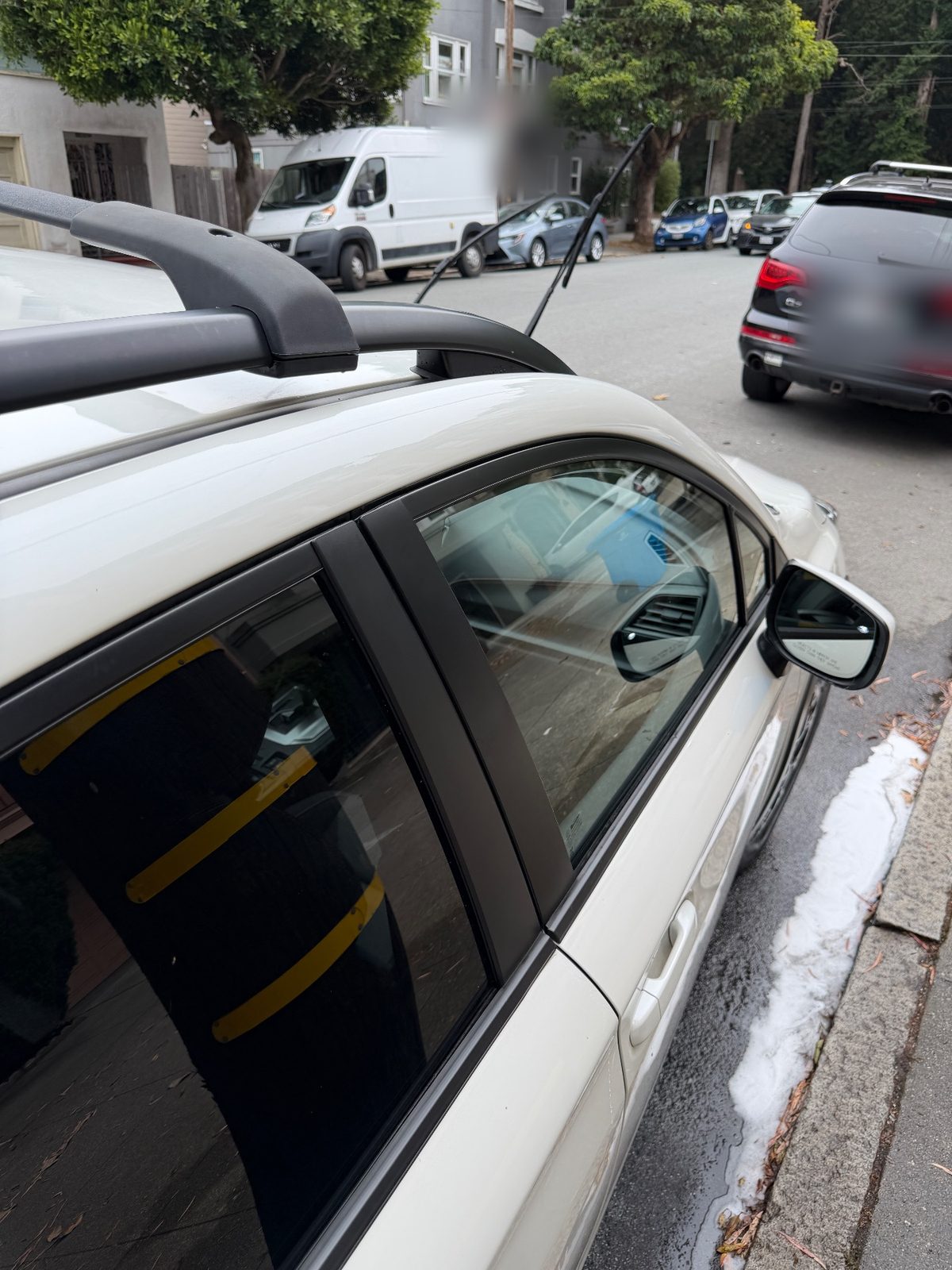 Clean roof rail and window trim of a white Subaru Crosstrek after washing