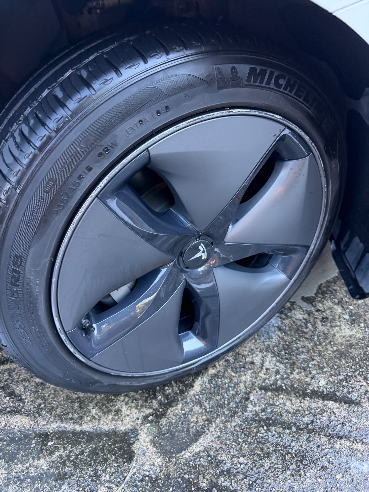 Clean aero wheel cover and Michelin tyre on a white Tesla Model 3 after detailing