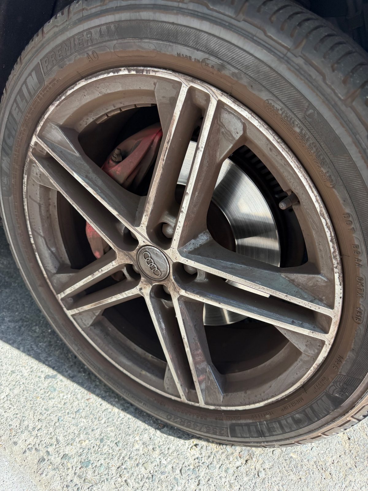 Dirty alloy wheel of an Audi SQ5 before cleaning, with brake dust and a brown tyre sidewall