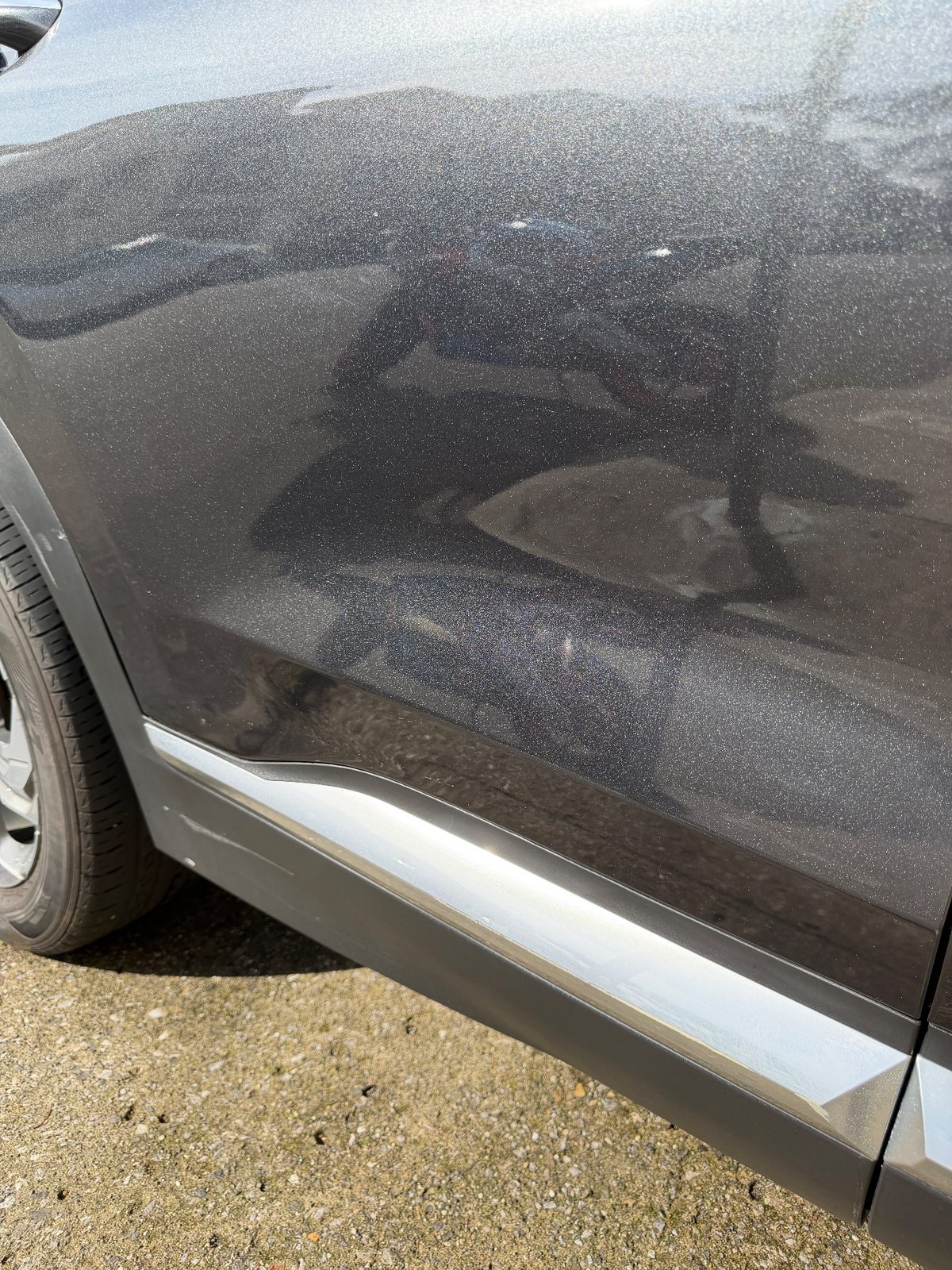 Clean rear passenger door of a dark grey Hyundai Santa Fe after detailing