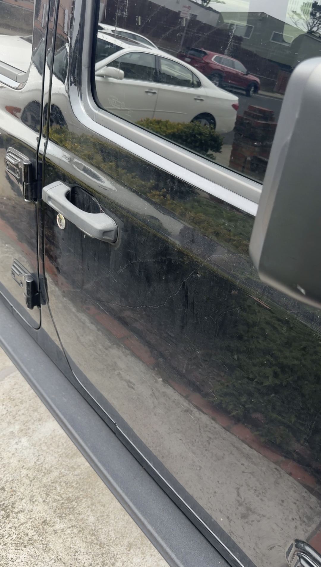 Dust haze on a black Jeep Wrangler front door and handle before cleaning