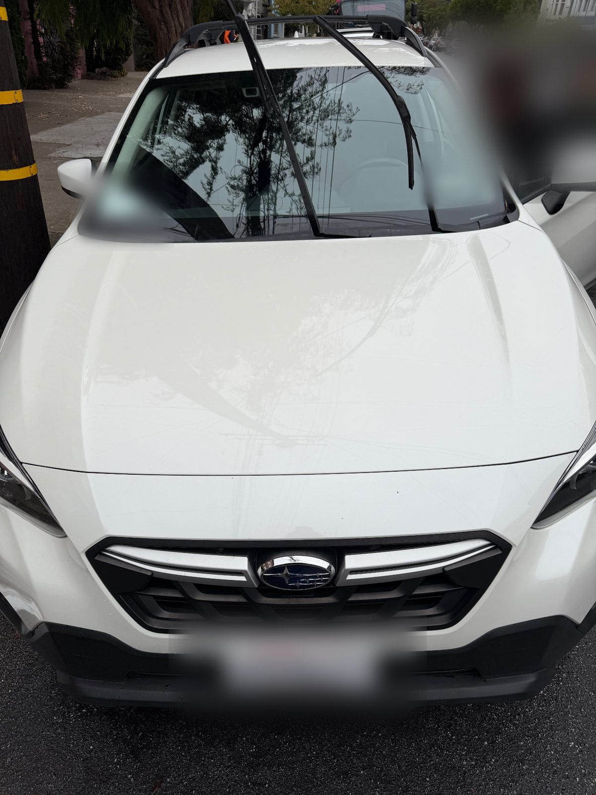 Front of a clean white Subaru Crosstrek after washing with a glossy hood and raised wipers
