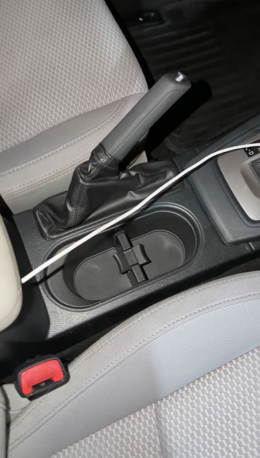 Centre console of a blue Subaru Forester after detailing, the twin cupholders clean beside the manual handbrake.