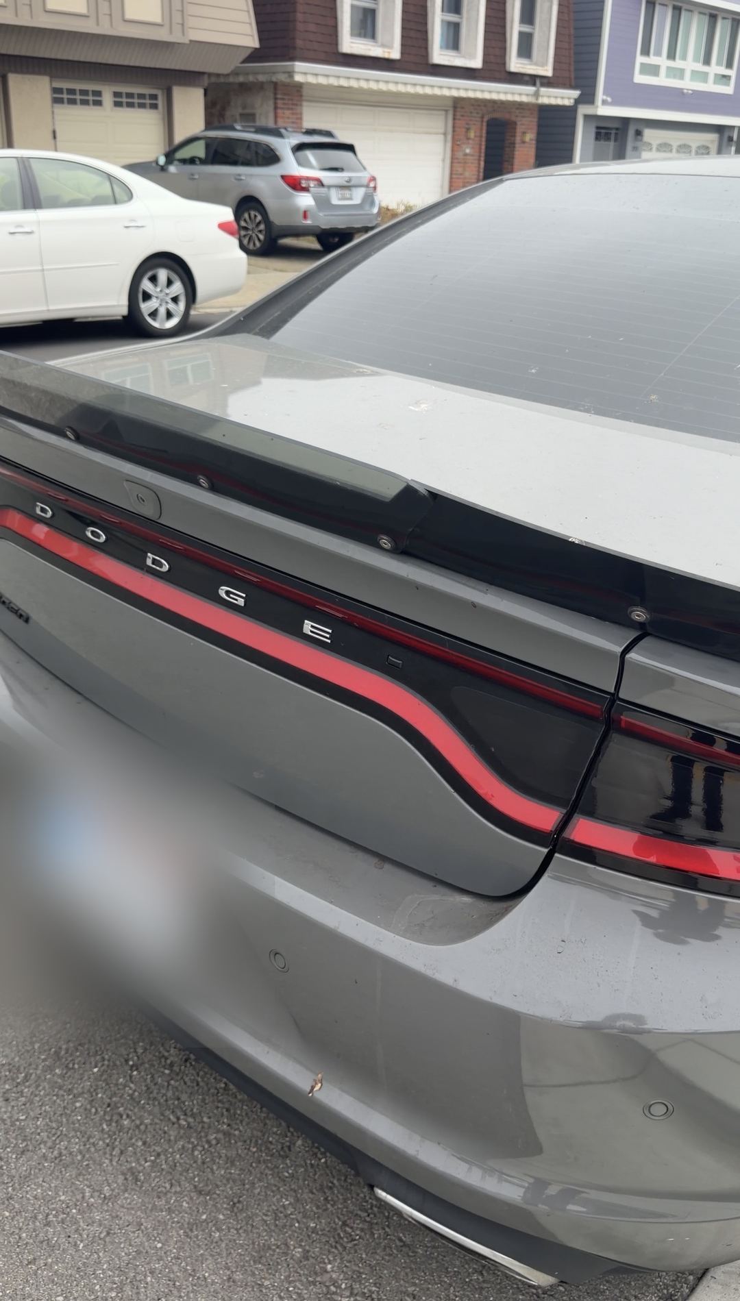 Rear of a grey Dodge Charger with dust specks on the decklid before cleaning