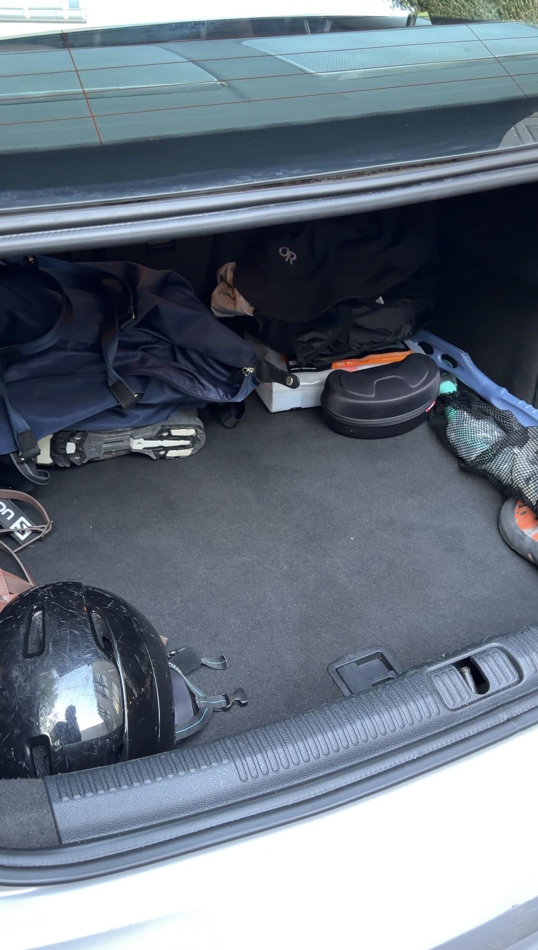 Clean carpet in an Audi A3 trunk holding the owner's helmet, bags and shoes