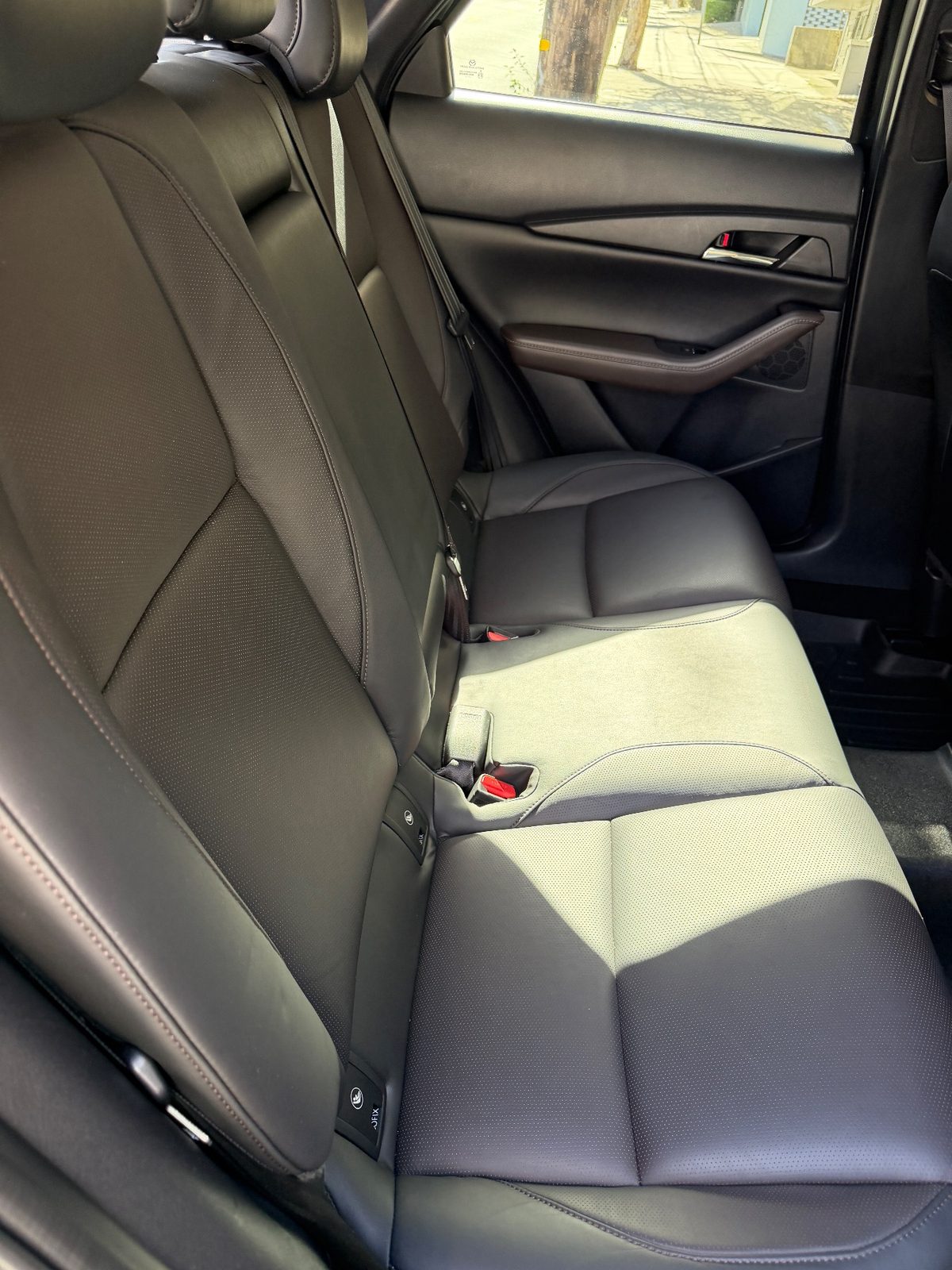 Rear bench of a grey Mazda CX-30 after cleaning, perforated leather clean