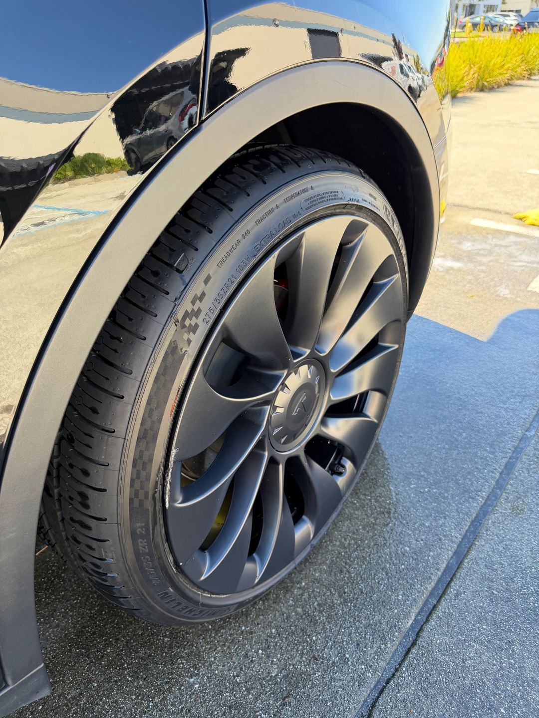 Cleaned wheel and dressed tyre on a black Tesla Model Y