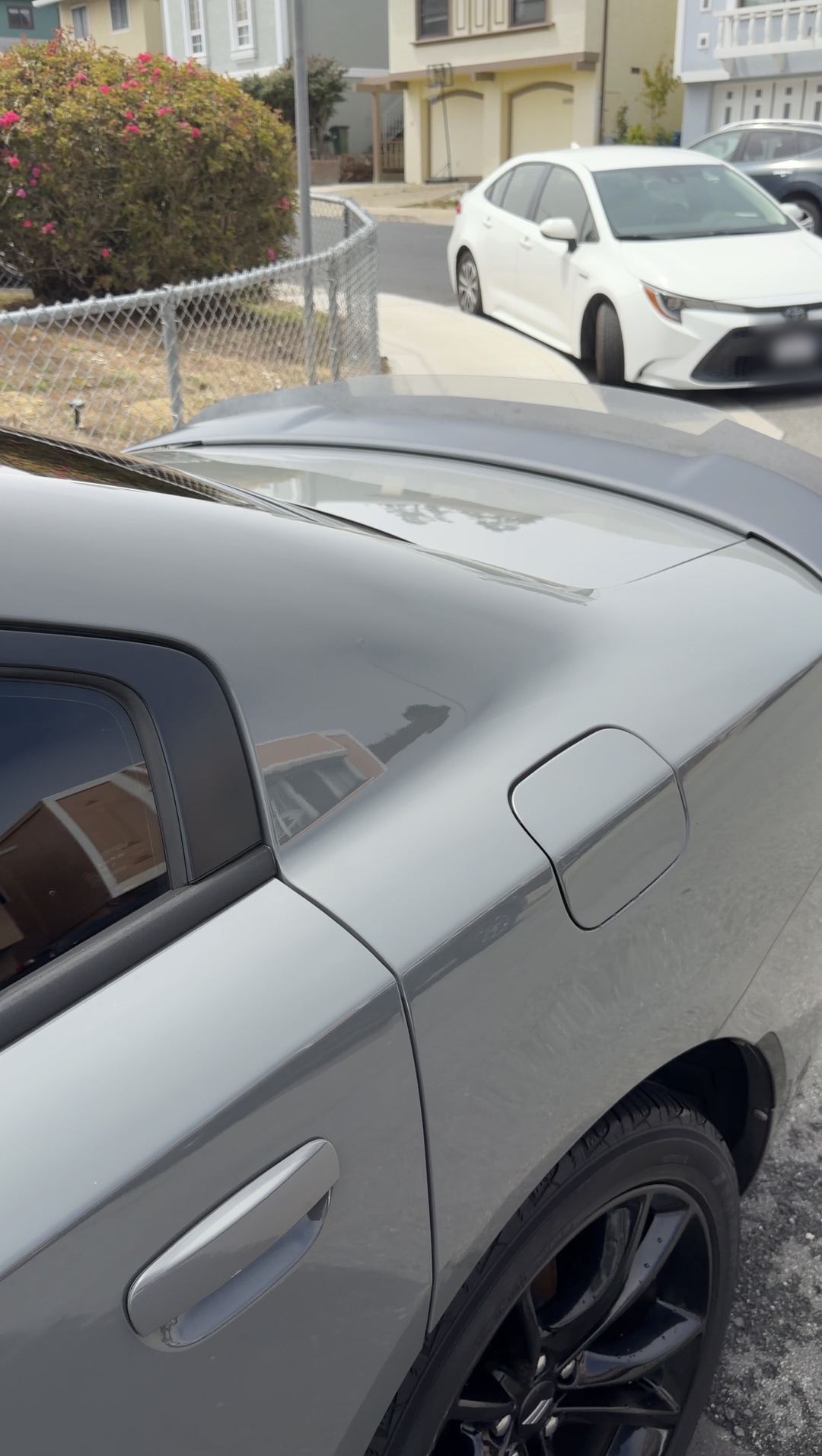 Clean grey Dodge Charger rear quarter and fuel door after an exterior detail