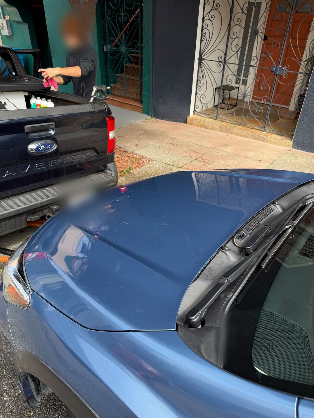 Clean hood and wiper cowl of a blue Subaru Crosstrek after washing, the twig and dust gone