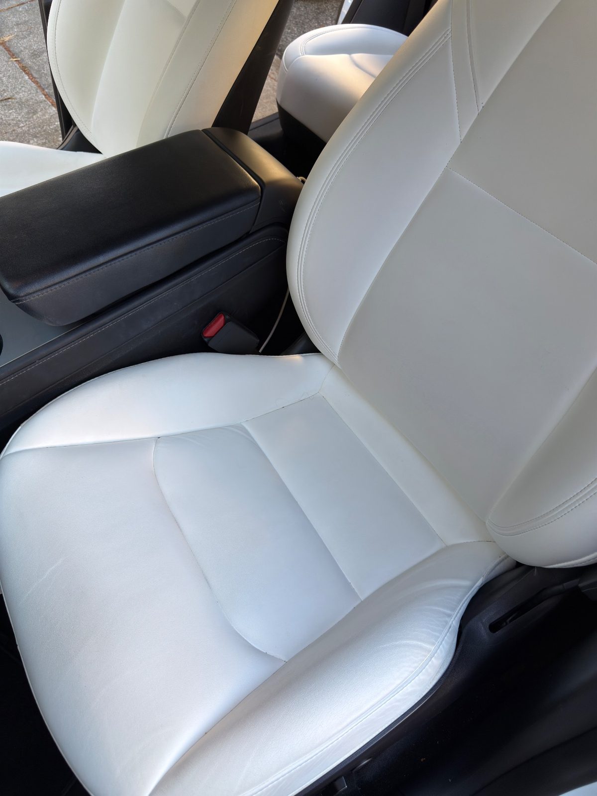 White leather driver seat of a Tesla Model Y before cleaning