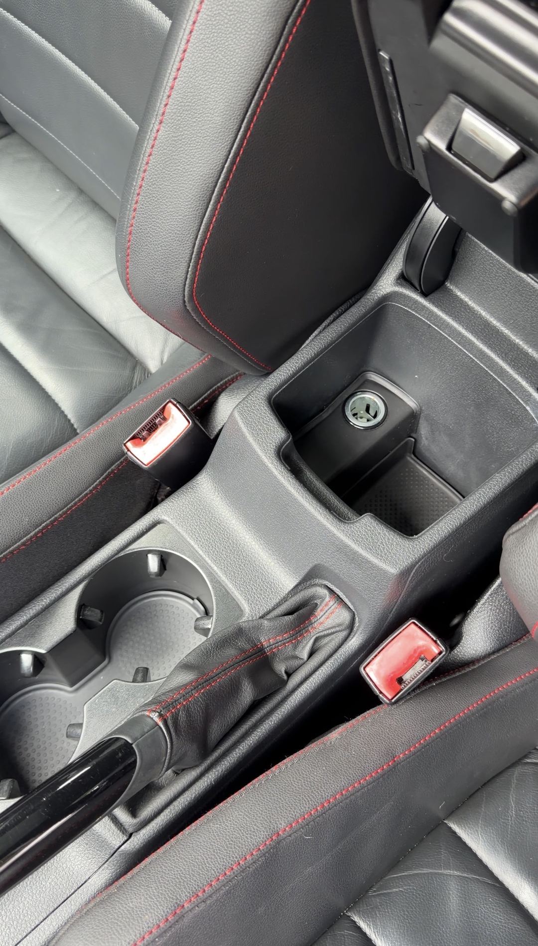 Armrest bin and cupholders of a VW GTI after cleaning, empty and dust-free
