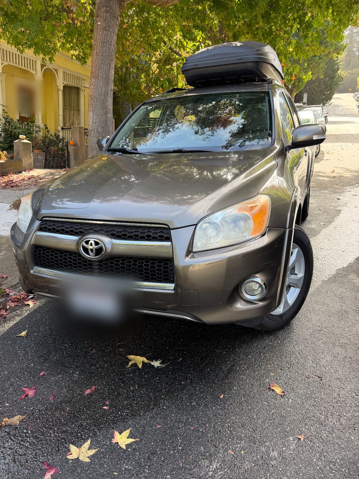Clean 2011 Toyota RAV4 with roof box, front three-quarter after washing