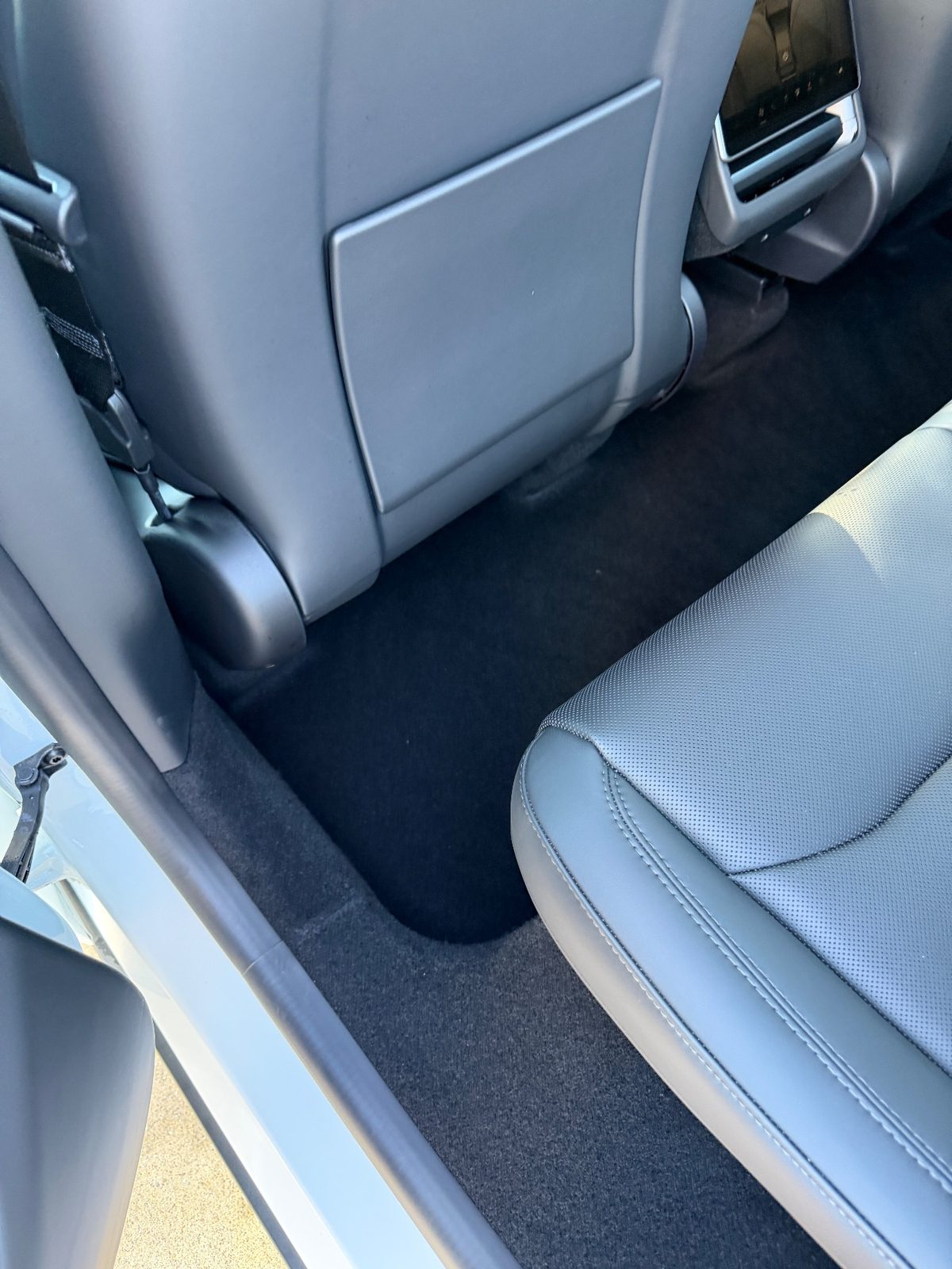 Clean rear footwell of a white Tesla Model Y after vacuuming