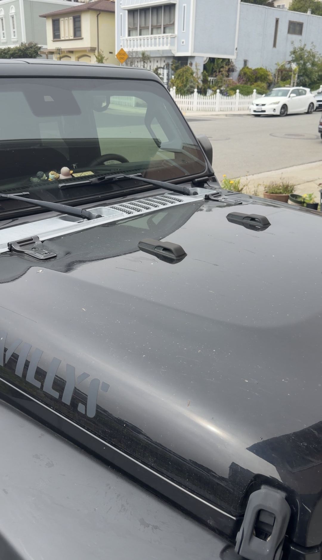 Dusty black Jeep Wrangler hood and windshield before an exterior detail