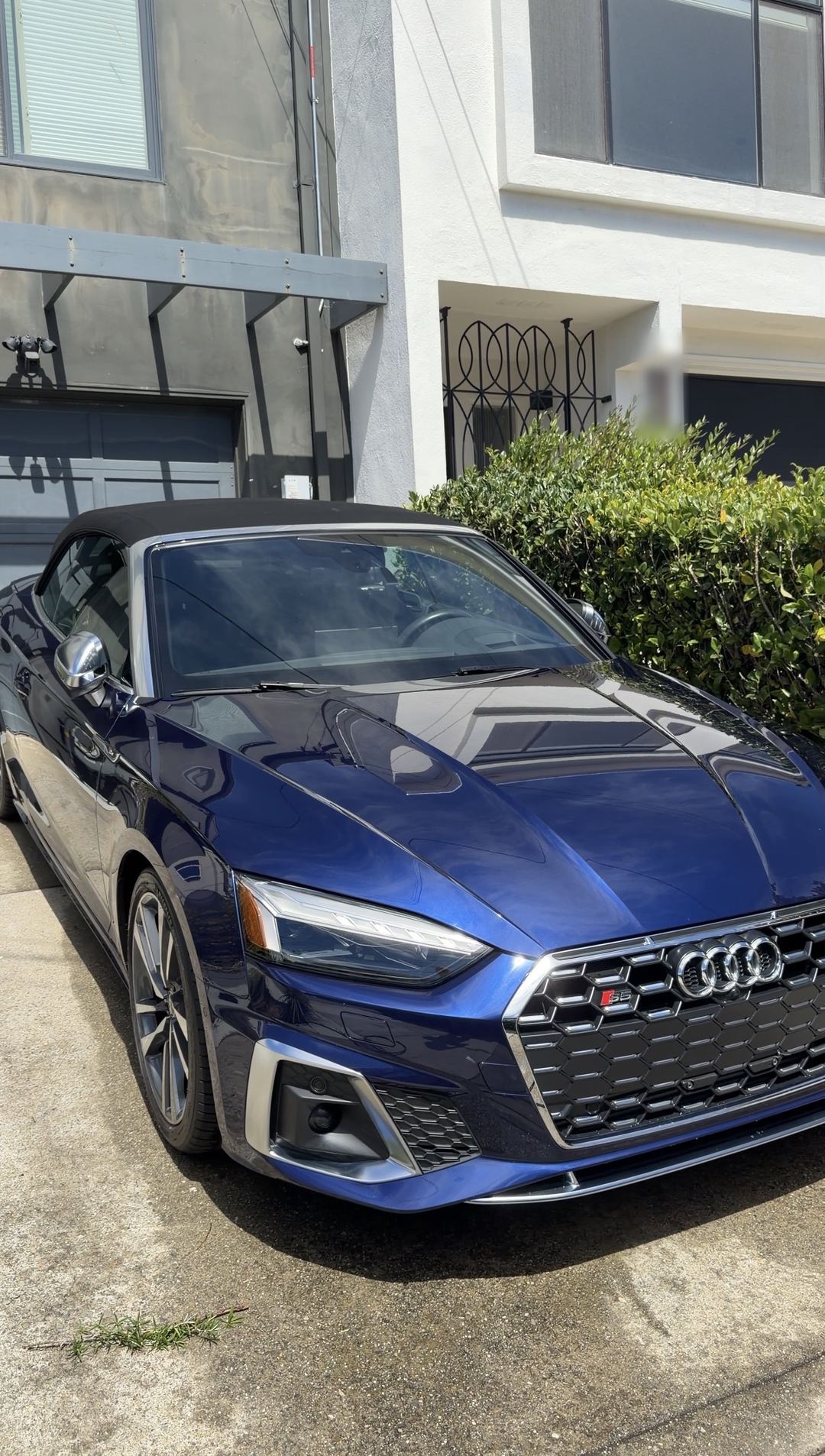 Clean blue Audi S5 Cabriolet with a black soft top parked in a residential driveway