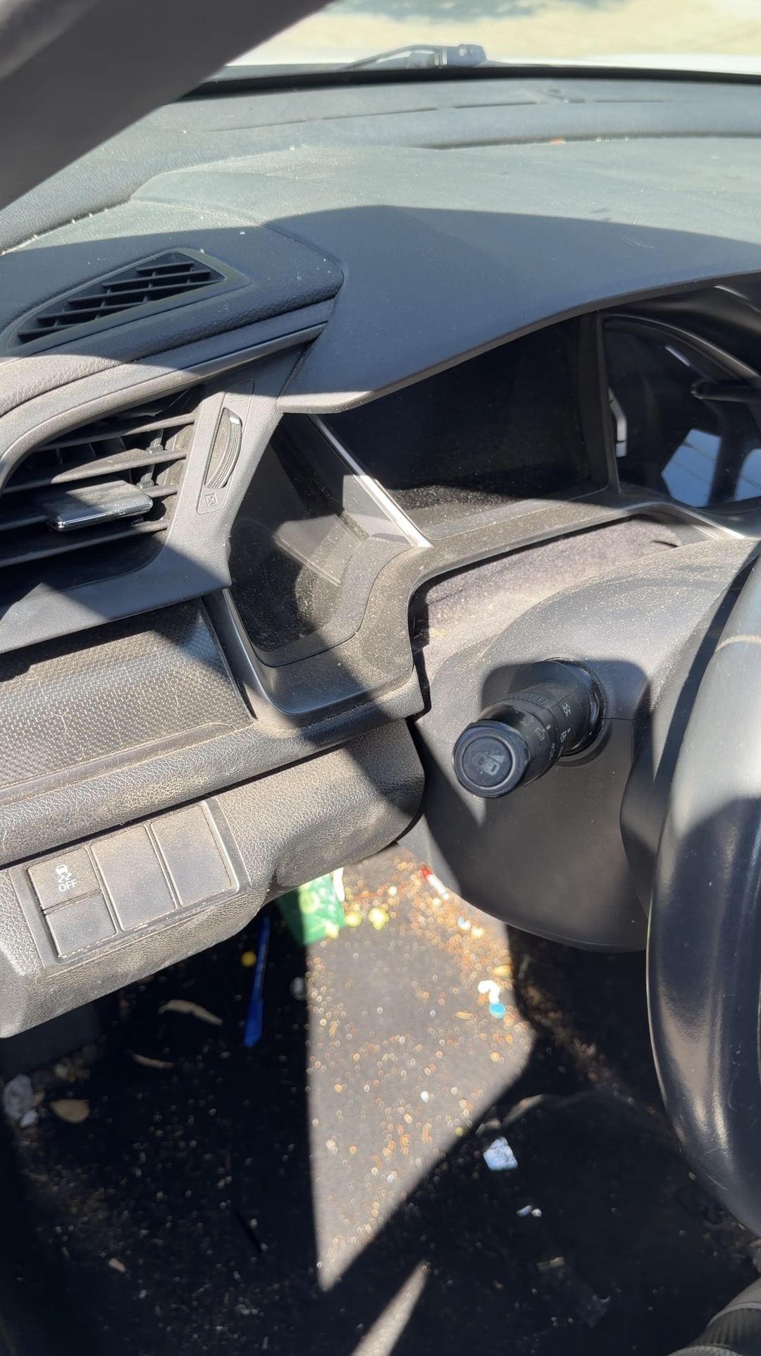 Dust-covered dash top and steering column of a Honda Civic before interior cleaning