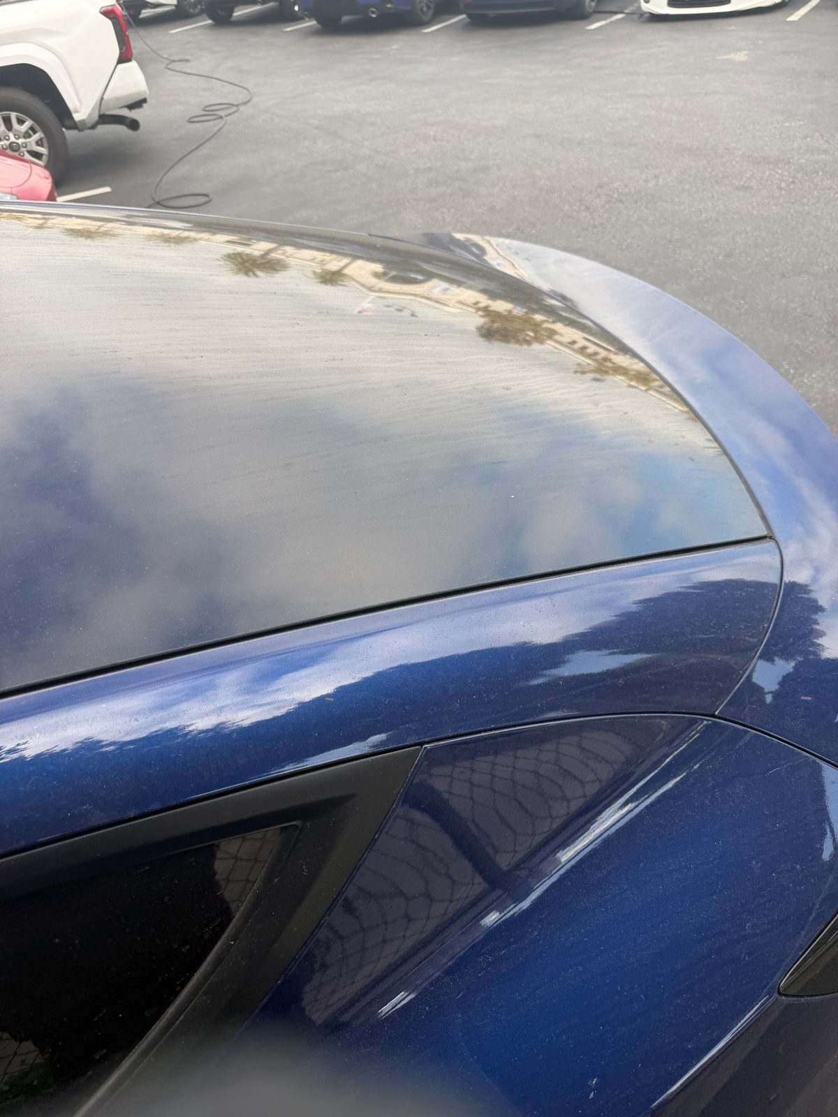Blue Tesla Model Y glass roof and spoiler before exterior detail, Downtown San Francisco