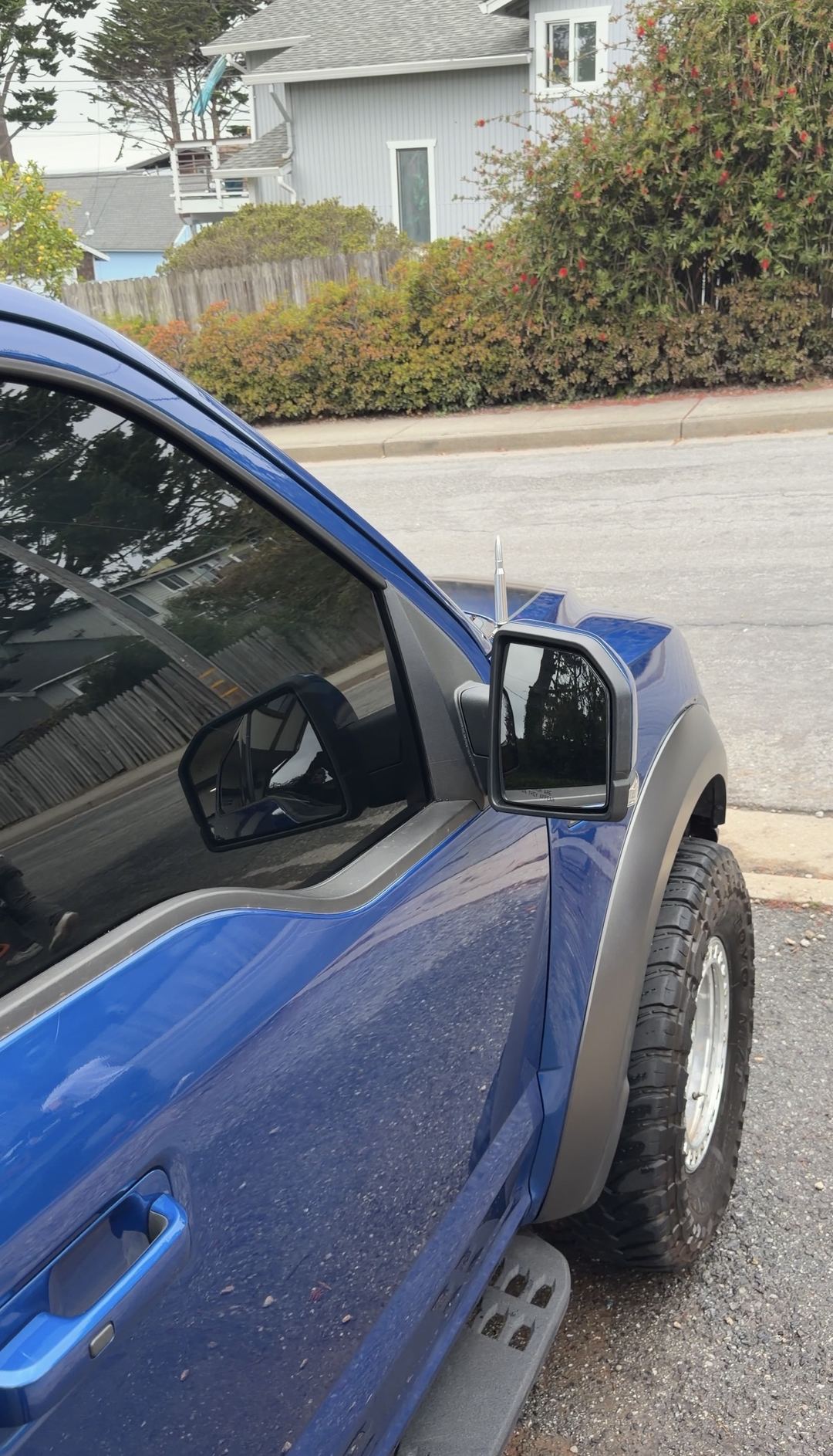 Clean hood and mirrors of a blue Ford F-150 Raptor after a mobile detail