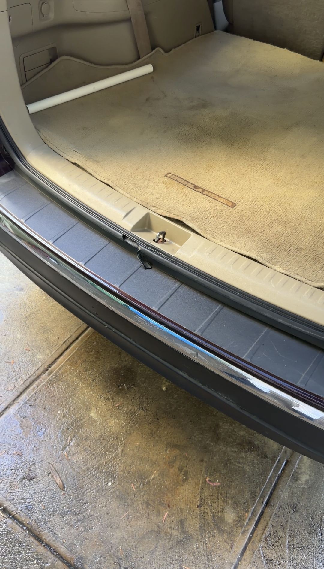 Cargo floor and clean rear sill of a Toyota Highlander after cleaning, with the carpet still marked