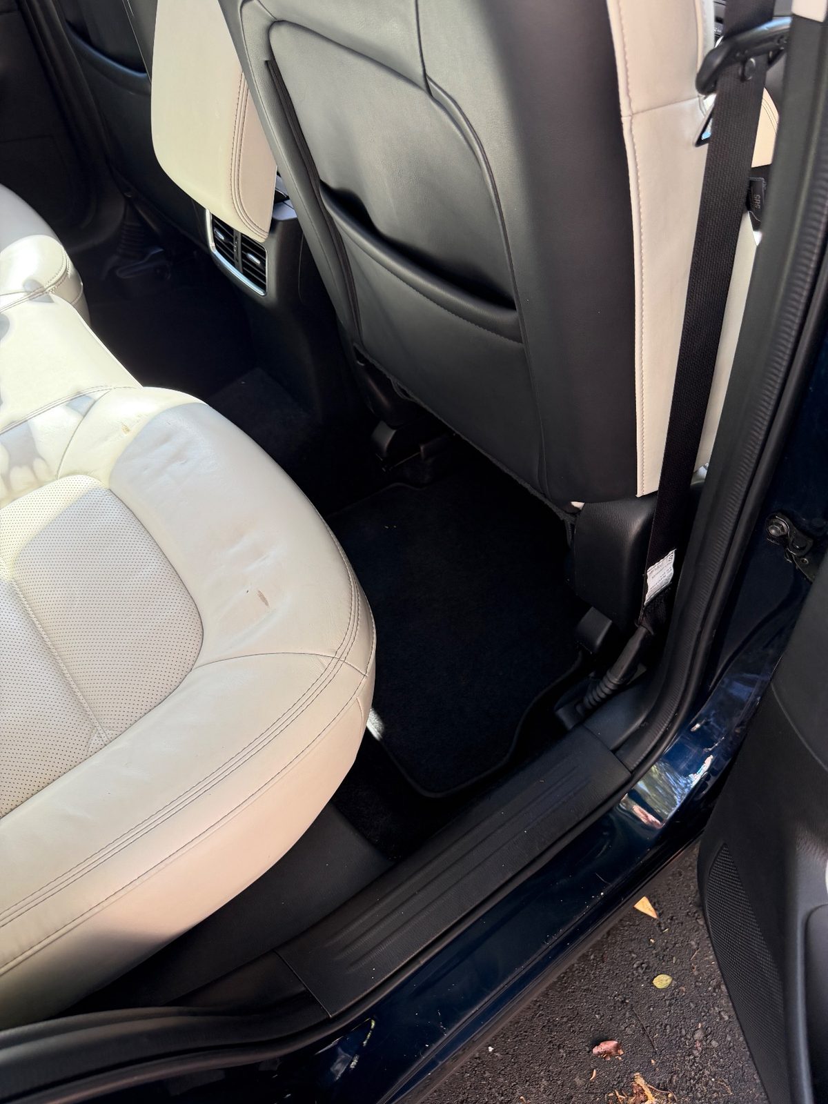 Clean rear footwell of a dark blue Mazda CX-5 after detailing, mat vacuumed and seat cleaned