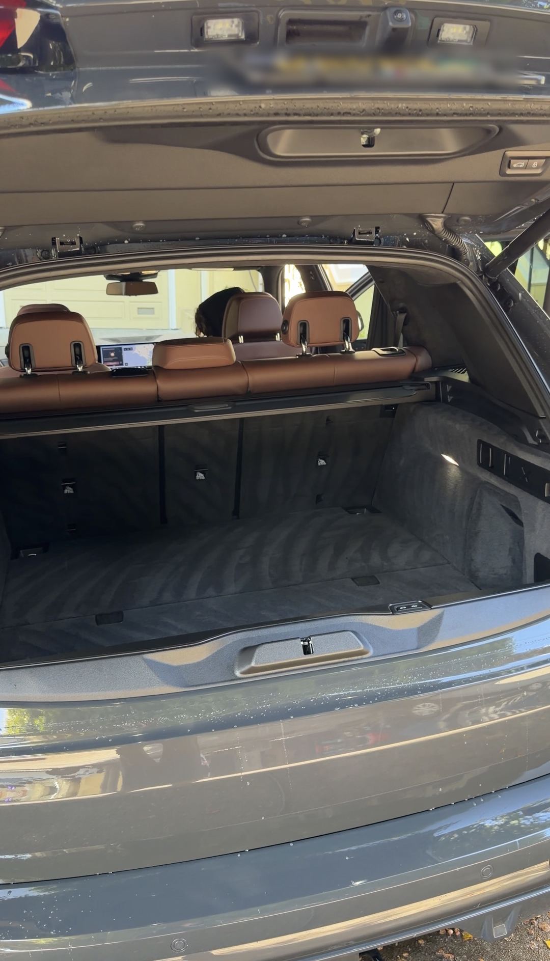 Cleaned cargo bay of a BMW X5 seen through the open tailgate after detailing