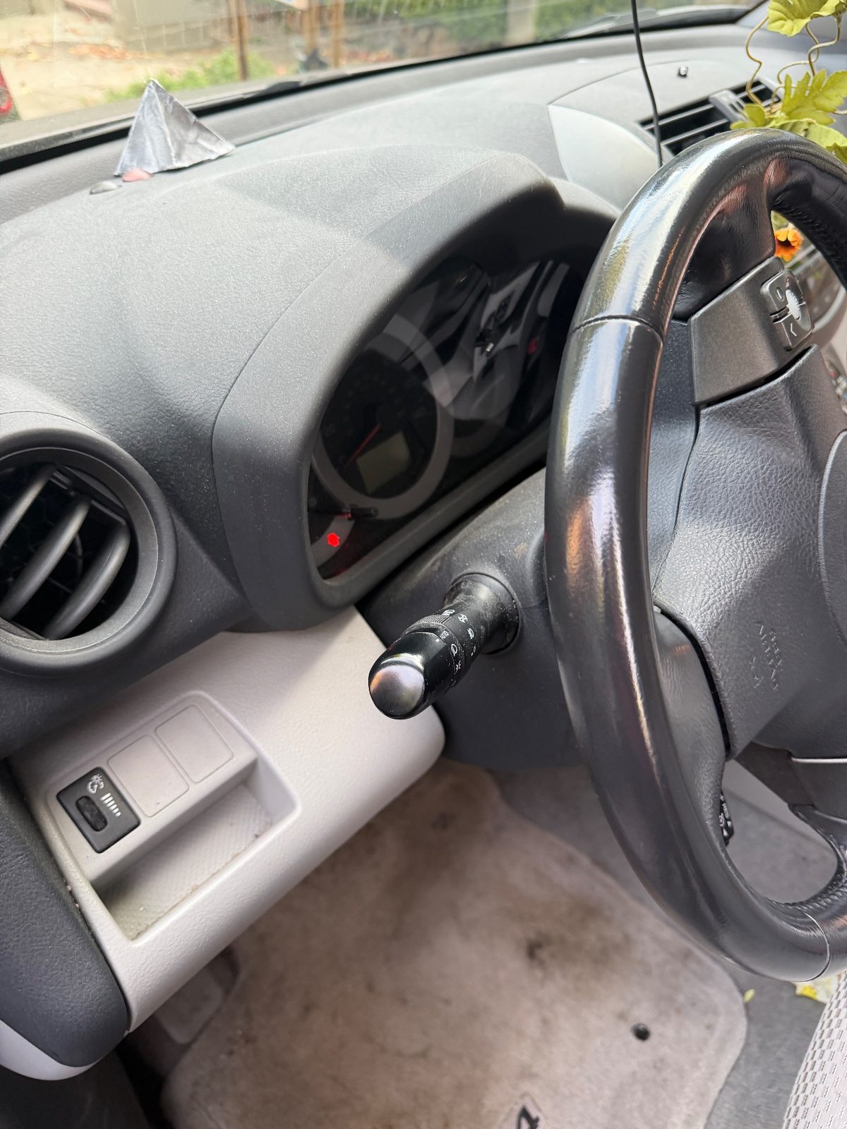 Dusty dash and steering column of a 2011 Toyota RAV4 before detailing