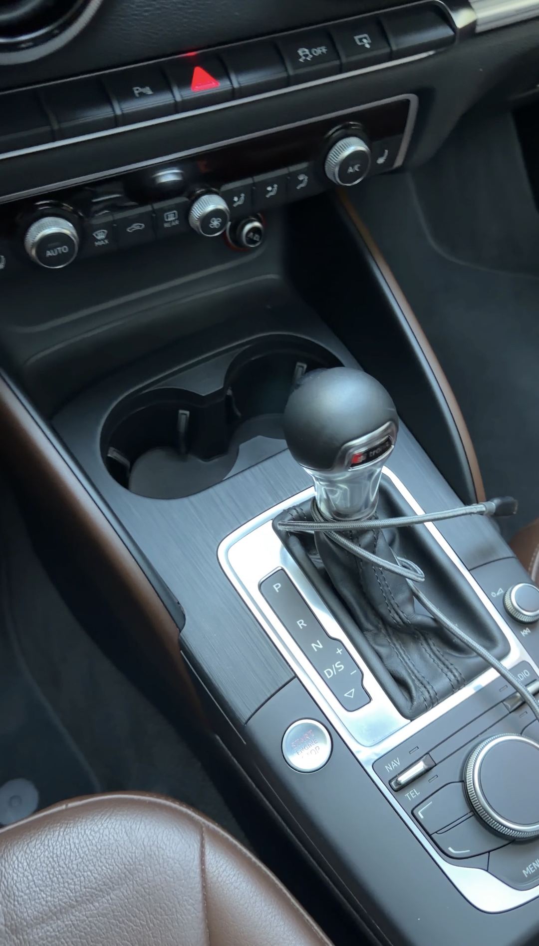 Clean center console of an Audi A3 with an S tronic shifter and empty cupholders