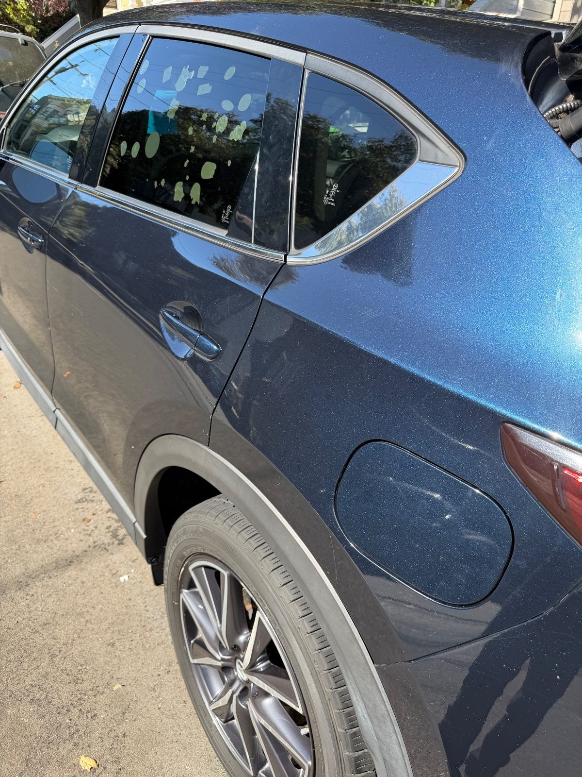 Rear quarter panel of a dark blue Mazda CX-5 after washing, glossy metallic blue paint