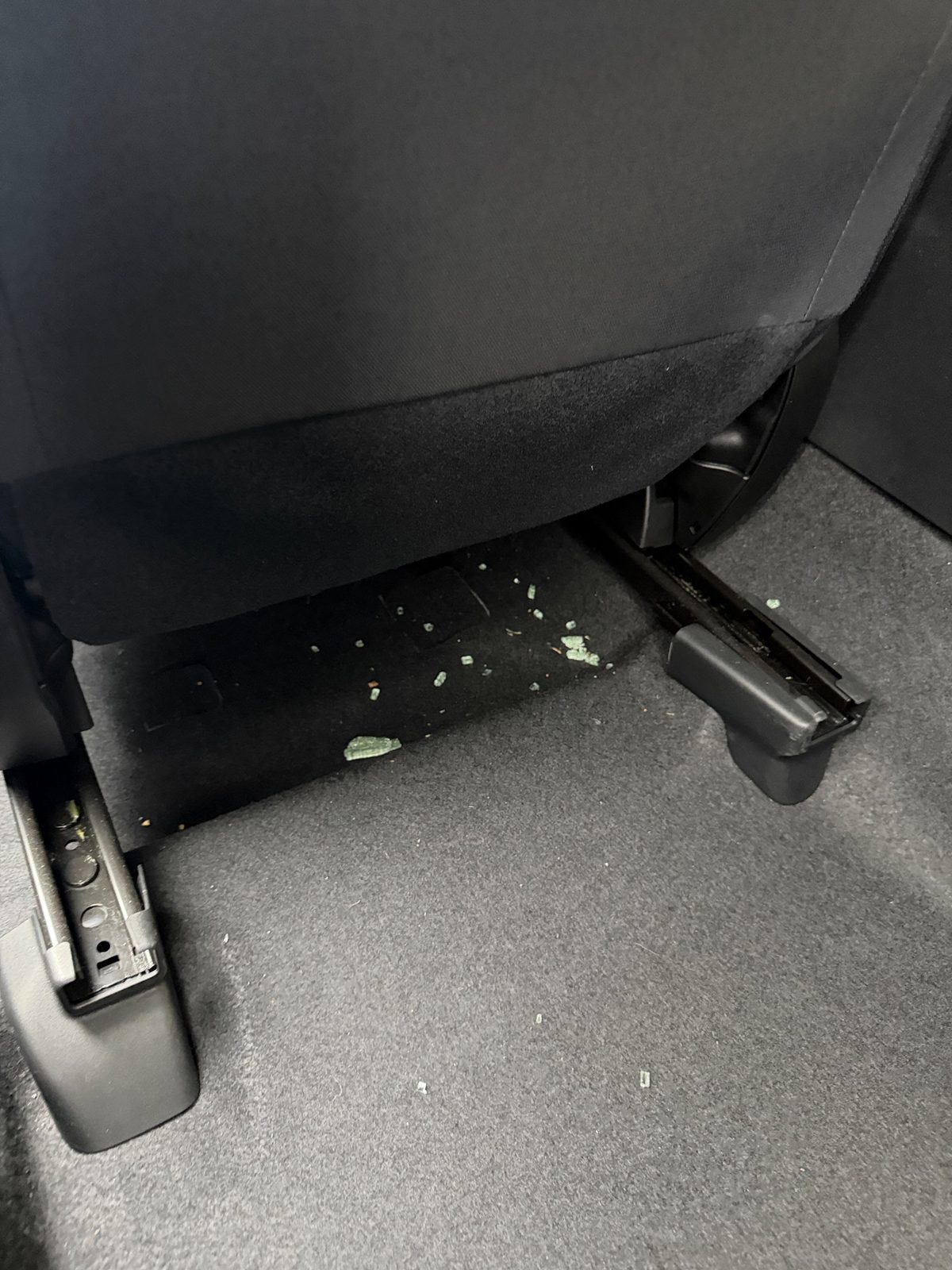Plant debris under a front seat of a Subaru Crosstrek before vacuuming