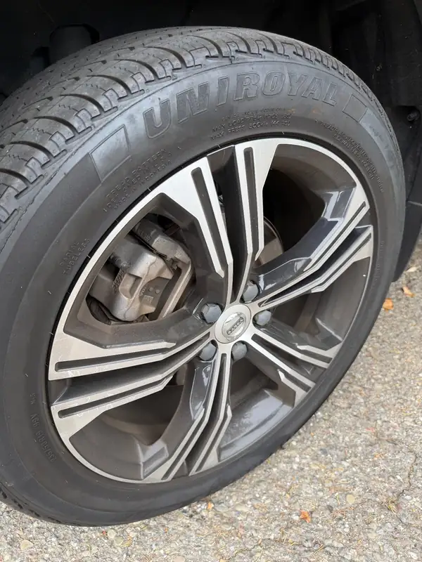 Dirty alloy wheel of a Volvo XC40 before cleaning, with brake dust on the spokes