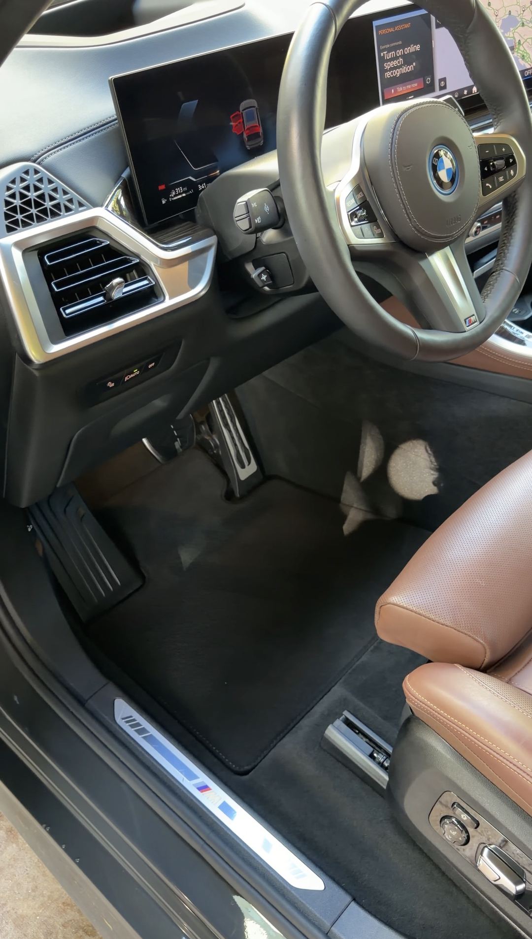 Driver footwell and cockpit of a BMW X5 after detailing, the floor mat clean and freshly vacuumed
