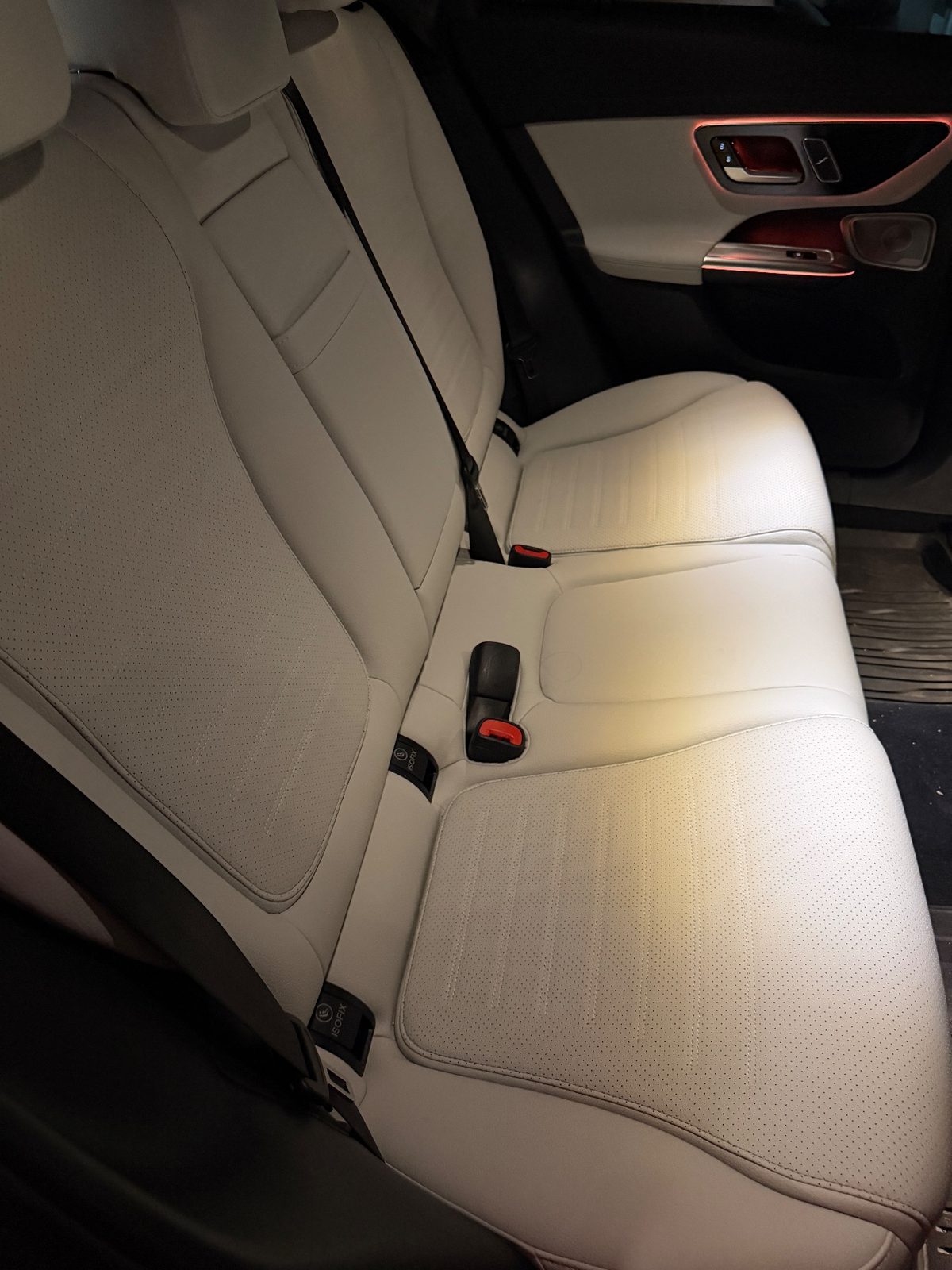 Rear bench seat of a white Mercedes GLC before cleaning, cream leather slightly dull