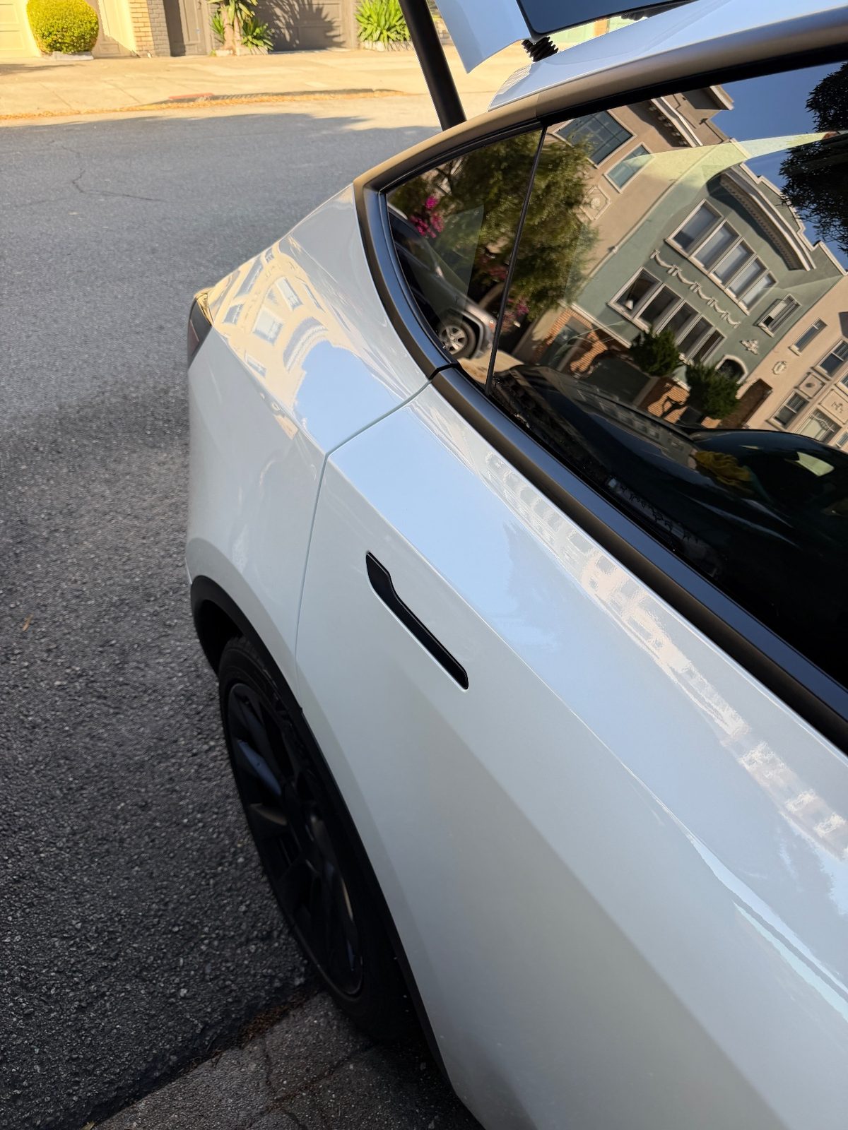 Glossy white rear quarter of a Tesla Model Y after detailing