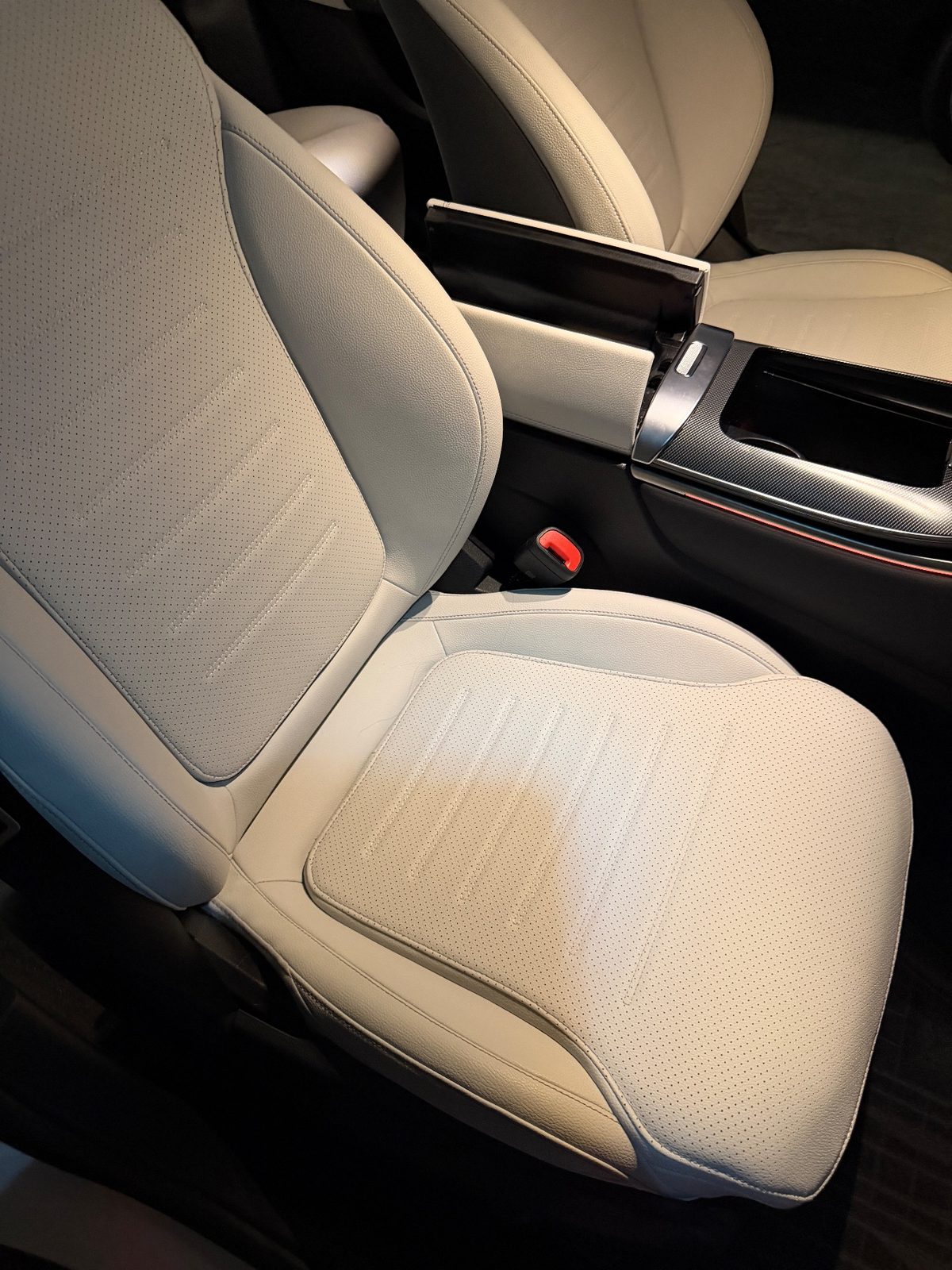 Driver seat of a white Mercedes GLC before cleaning, tan stain across the cream leather cushion