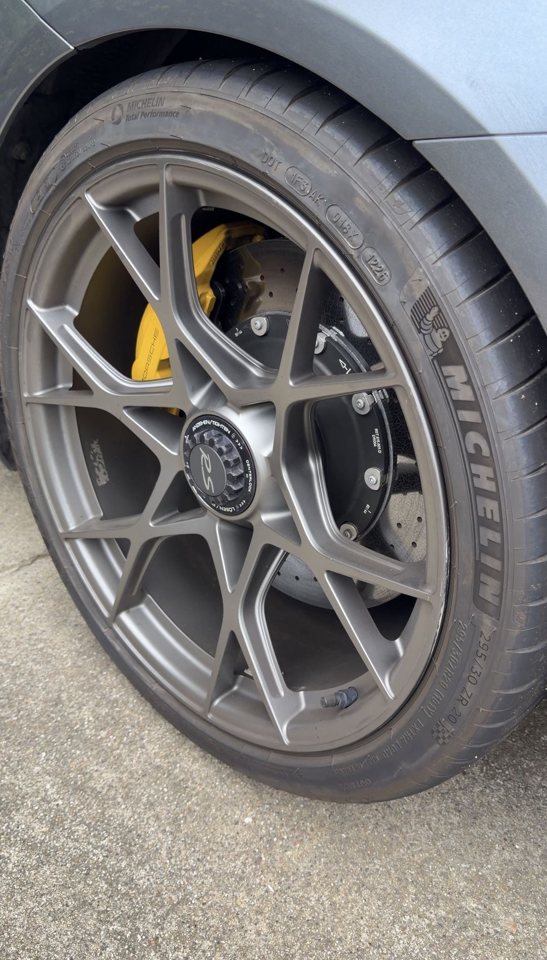 Close-up of a Porsche 718 Spyder RS centre-lock forged wheel with a yellow ceramic-brake caliper and Michelin Cup 2 tyre.