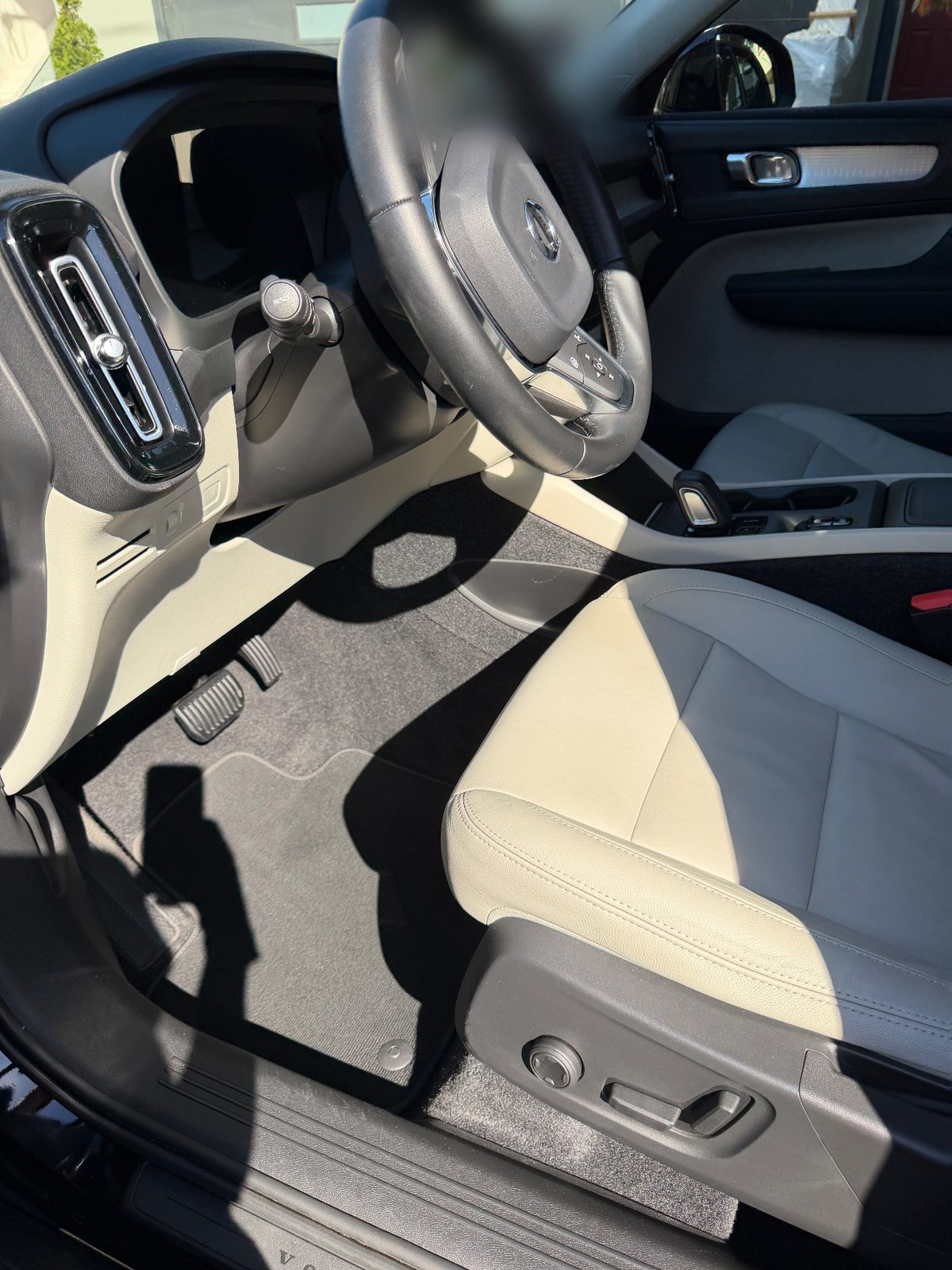 Clean driver side cabin of a Volvo XC40 after detailing, with vacuumed mat and wiped dash