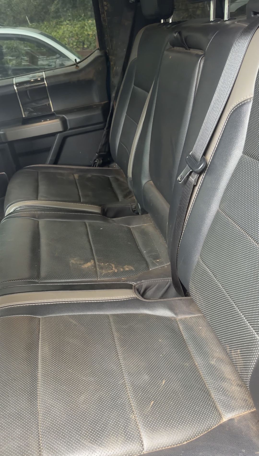Soiled rear bench seat of a Ford F-150 Raptor before an interior detail
