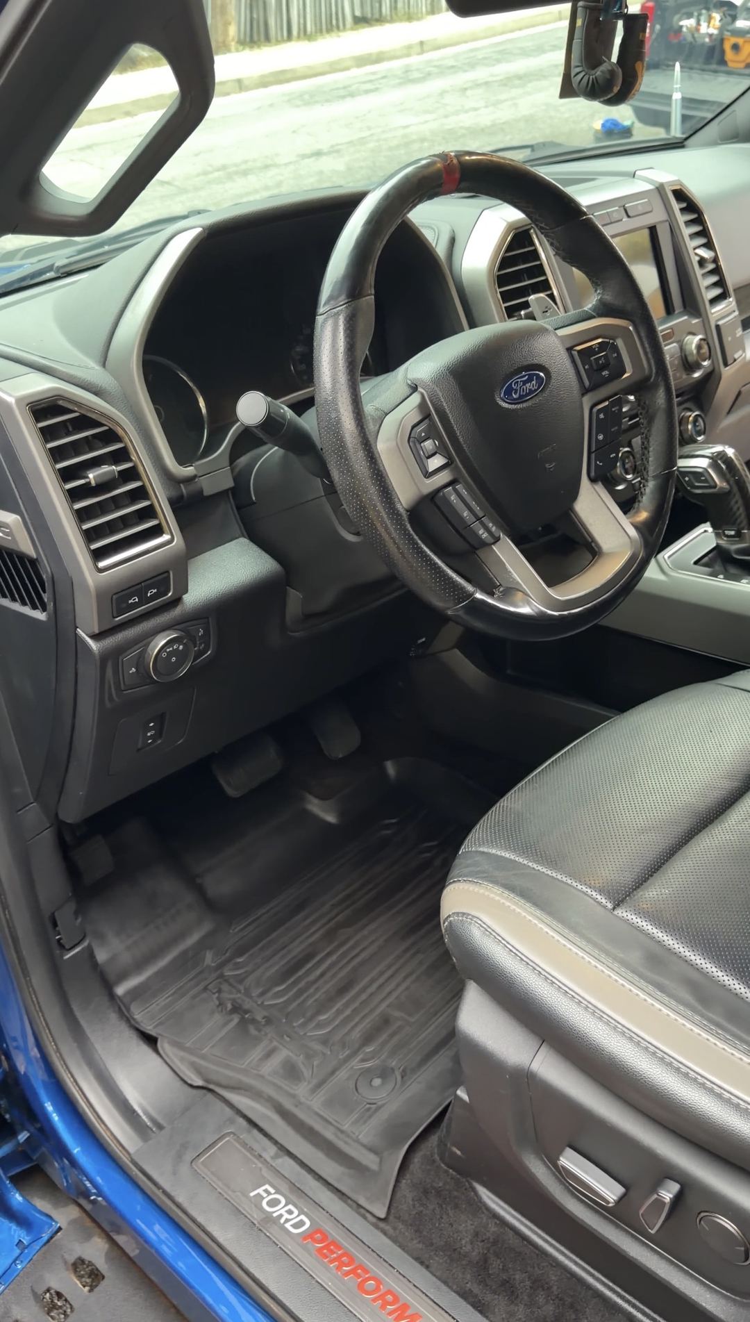 Clean driver's footwell and dash of a Ford F-150 Raptor after an interior detail