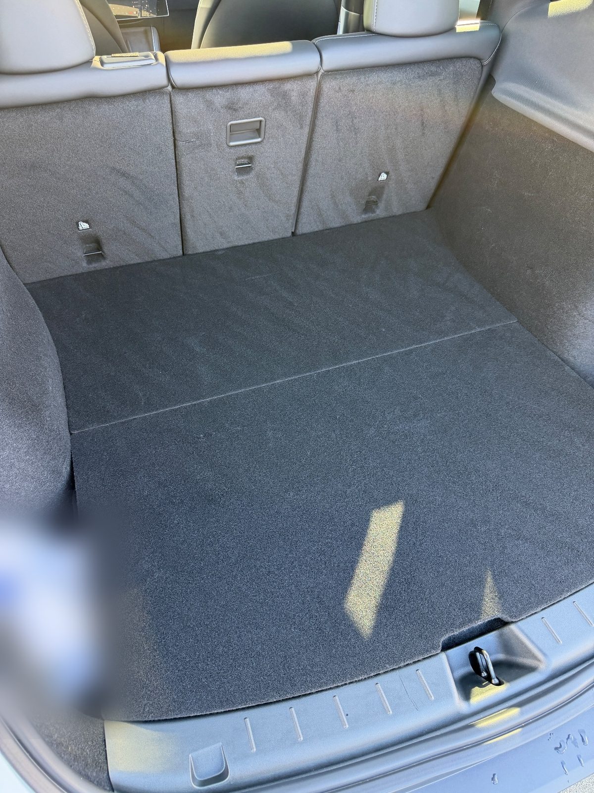 Clean cargo area of a white Tesla Model Y after vacuuming