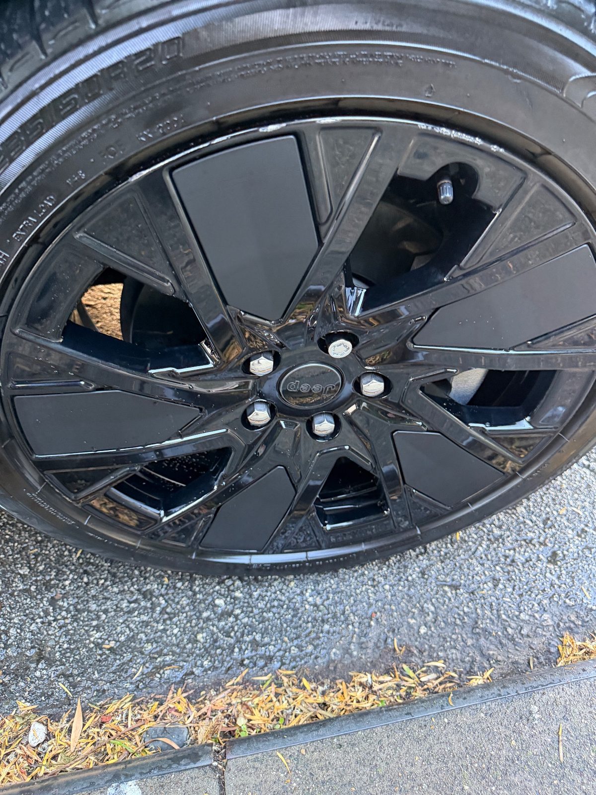 Close-up of a clean gloss black Jeep wheel after detailing