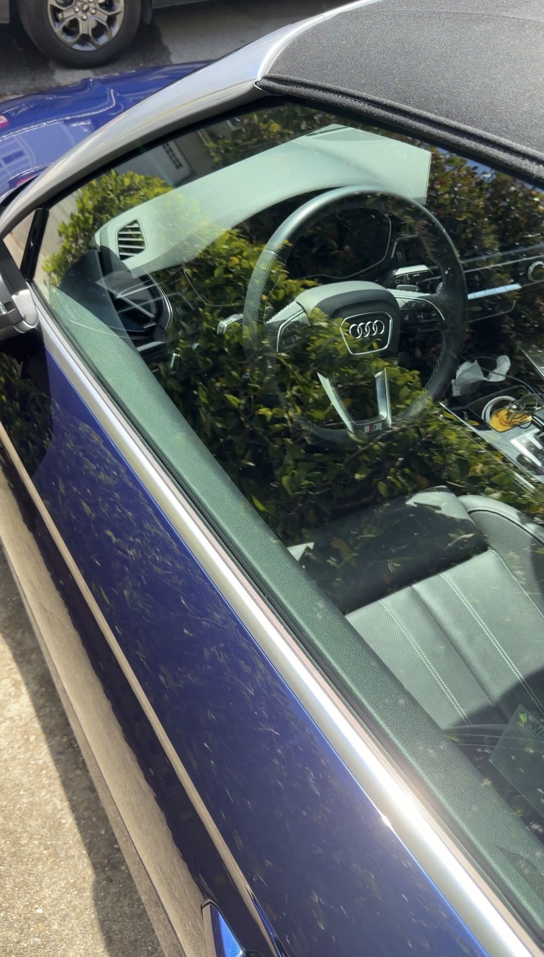 Clean driver window trim of a blue Audi S5 Cabriolet with the steering wheel visible