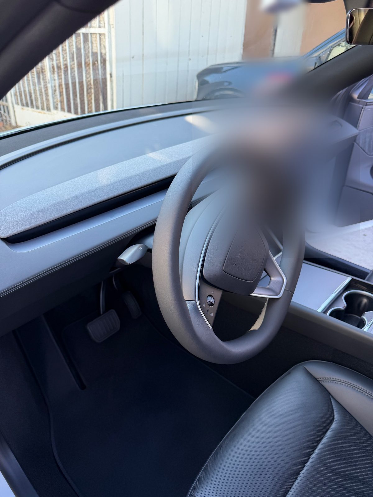 Clean dash and driver footwell of a white Tesla Model Y after detailing