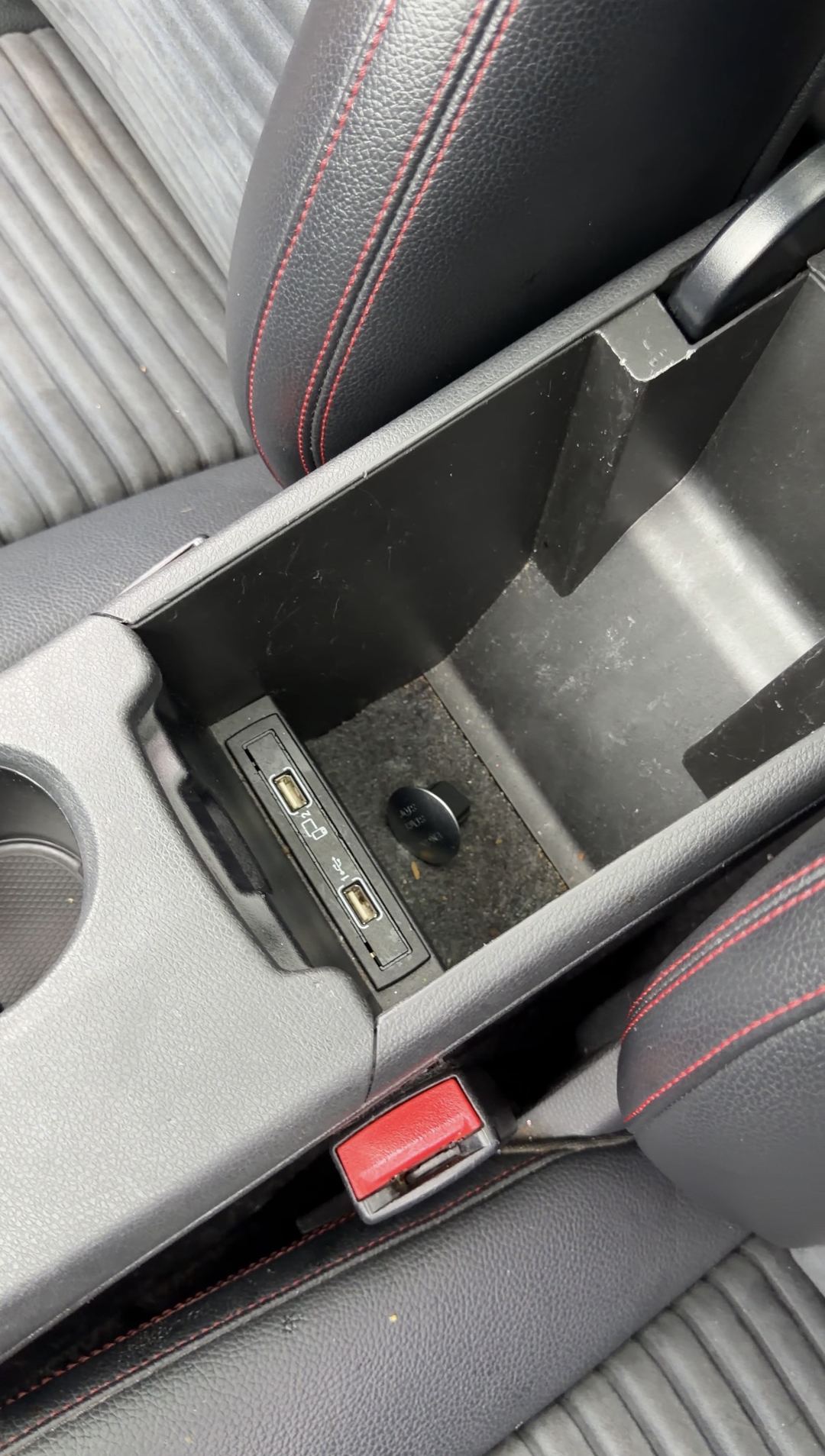 Open centre console storage bin of a Mercedes-Benz CLA250 showing grit around the USB sockets before detailing