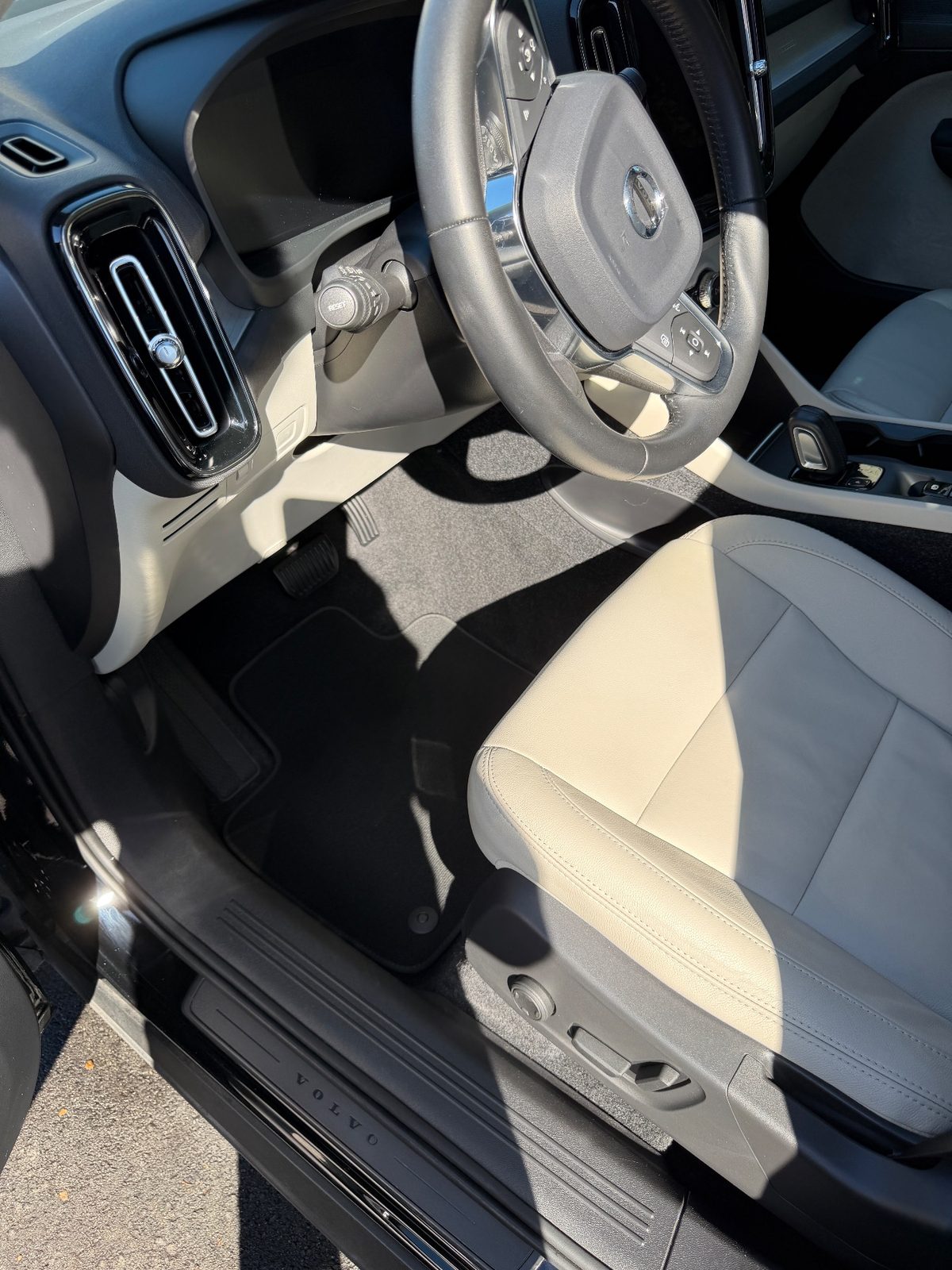 Vacuumed driver footwell of a Volvo XC40 after detailing, with a clean black mat and carpet