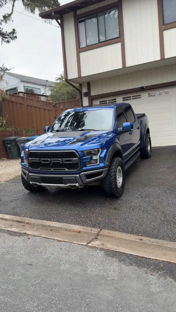 Clean blue Ford F-150 Raptor on a driveway after a mobile detail