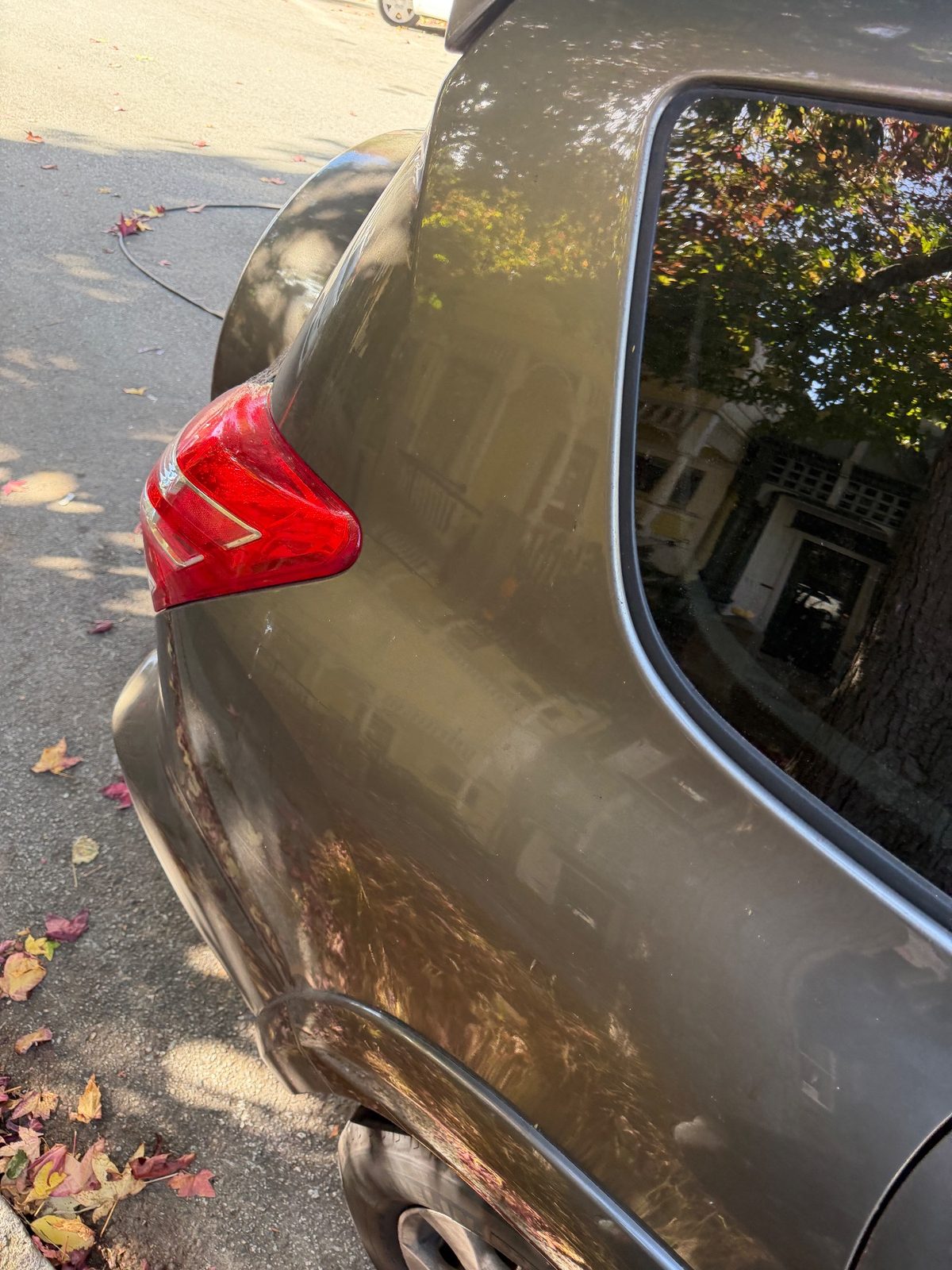 Dusty rear quarter and tail lamp of a 2011 Toyota RAV4 before washing